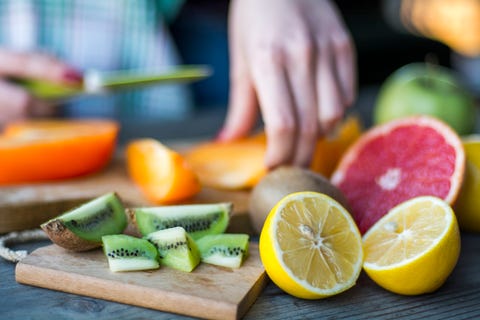 Woman's hands cuts fresh persimmons