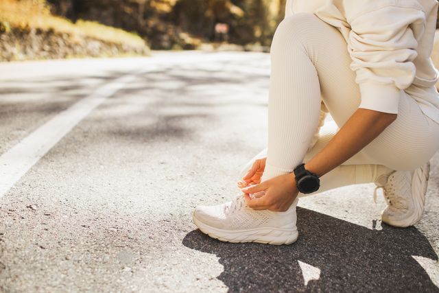 woman's hands tying shoes before running or jogging outdoors