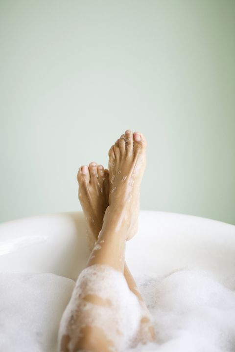 woman's legs and feet in bathtub with bubbles