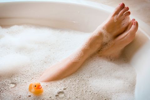 woman's legs in bubble bath with ducky