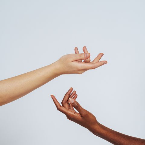 women stretching hands toward each other against white background