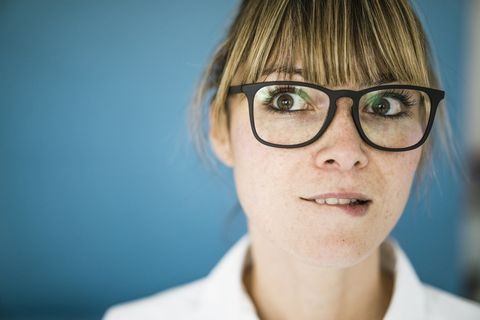 Portrait of woman with glasses biting on her lip