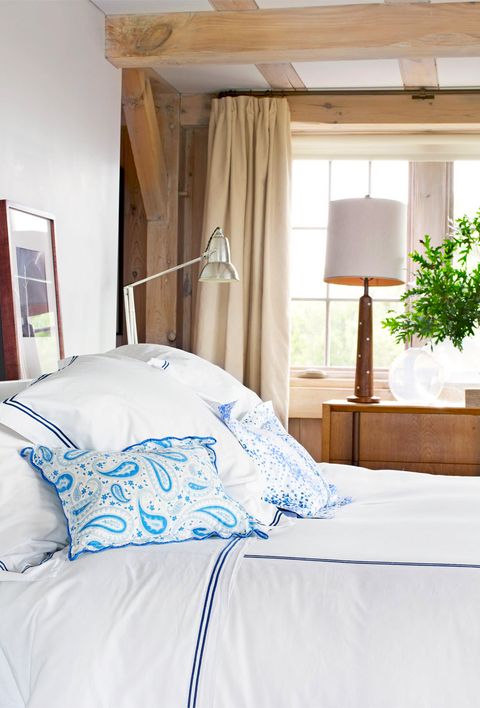 bedroom with blue and white bedding and wood ceiling