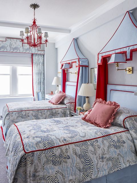 in daughter kingsley's room, tomato red trim by kravet and a painted wrought iron chan­delier crown a sweep of soft blues