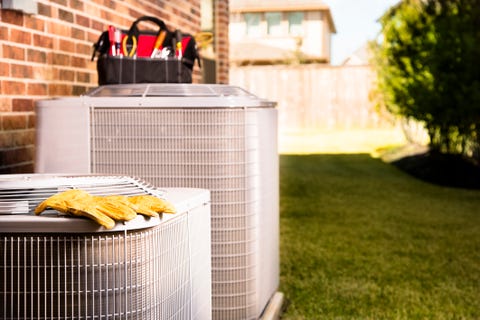 Service Industry: Work tools on air conditioners. Outside residential home.