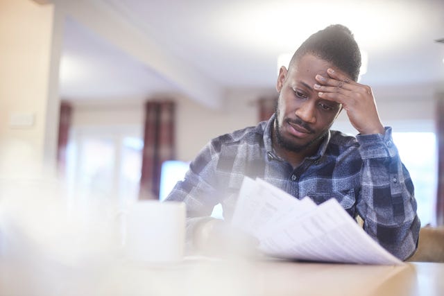 inquiet jeune homme lisant les factures des ménages