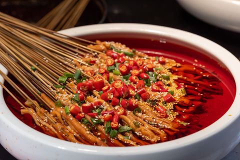 yachang duck intestines skewers in a bowl with spicy oil sauce