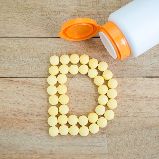yellow pills forming shape to d alphabet on wood background ビタミンd　メリット　摂取　日光　健康　ヘルスケア
