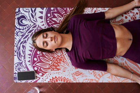 Young brunette woman practising yoga in student dorm Yoga en casa para principiantes