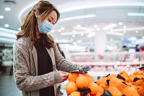 young asian lady in medical face mask shopping in a supermarket