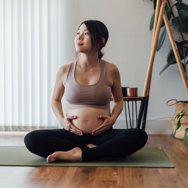 young asian pregnant woman practising yoga at home