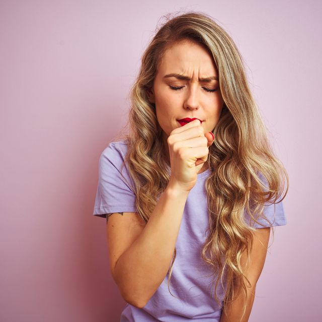 young beautiful woman wearing purple t shirt standing over pink isolated background feeling unwell and coughing as symptom for cold or bronchitis healthcare concept
