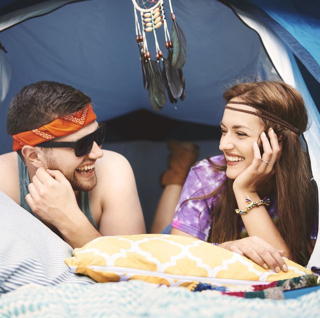 young boho couple lying in tent at festival