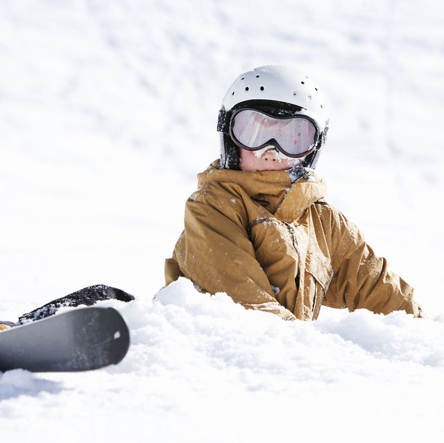 jonge jongen in sneeuw met skipak en ski's
