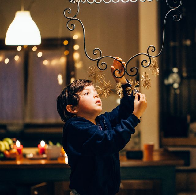 niño decorando lámpara en navidad