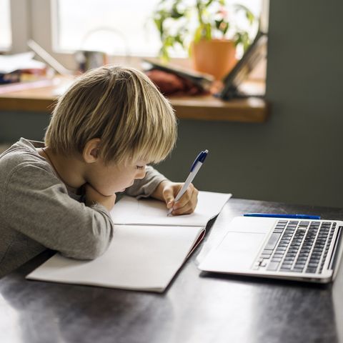 niño haciendo deberes y ordenador
