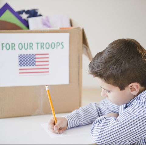 young boy preparing care package for us troops
