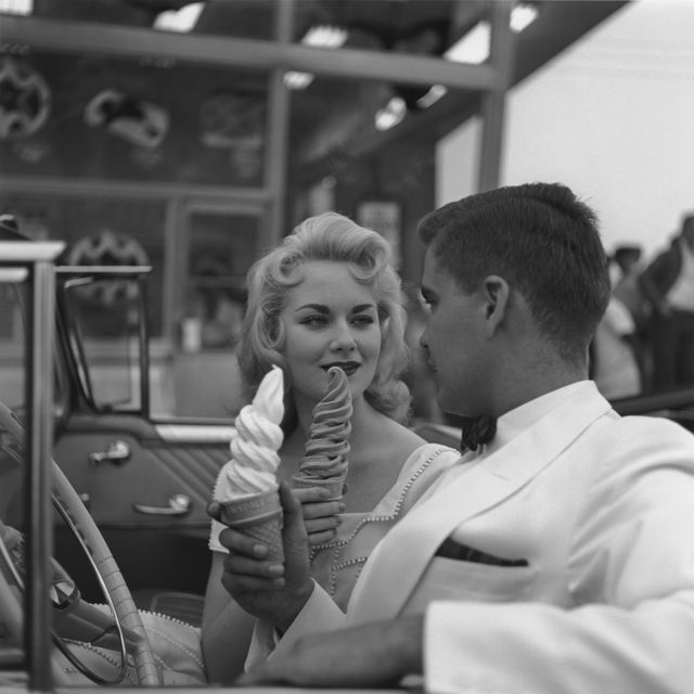 couple sharing ice cream in convertible