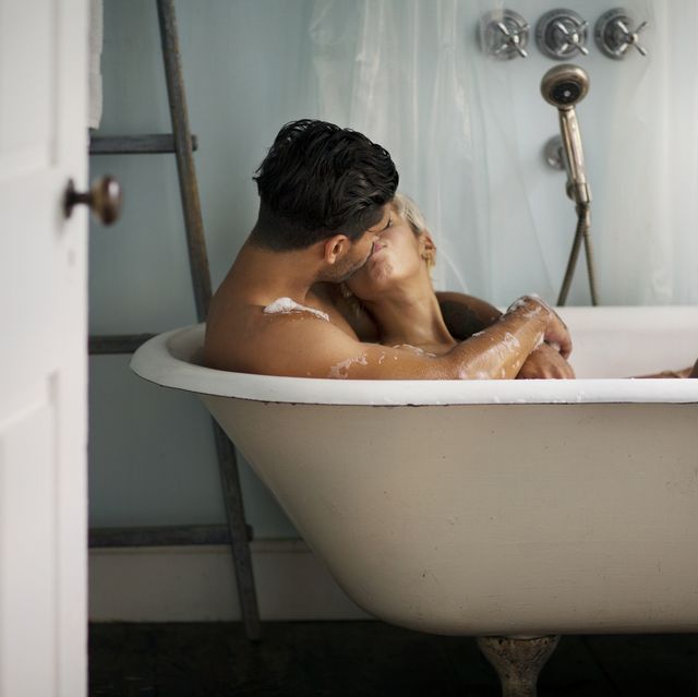 young couple kissing in bathtub at home