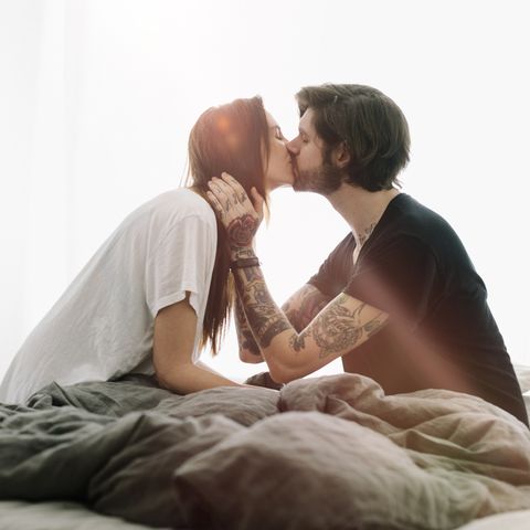 A young couple kissing in bed