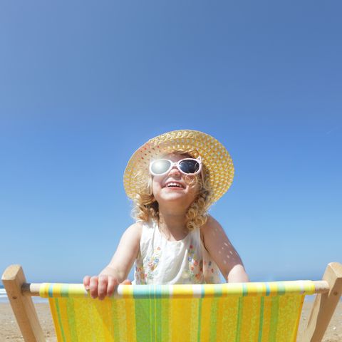 niña con gafas de sol en la playa
