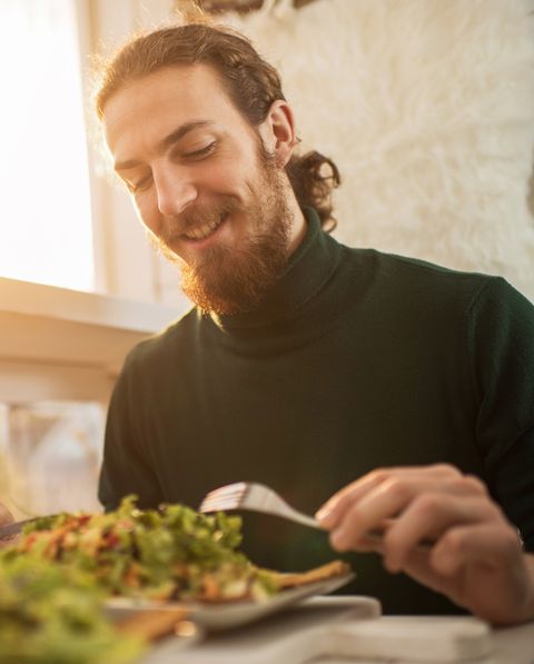 Young happy man enjoying in a healthy meal.