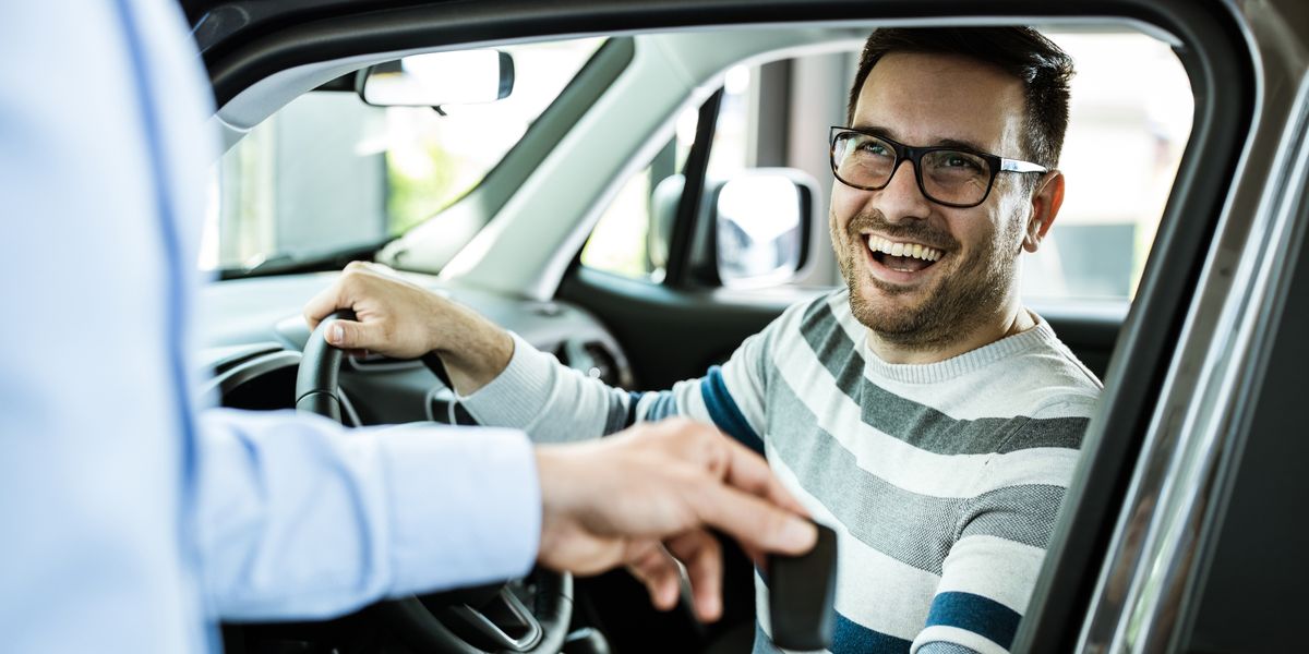 young happy man receiving new car keys in a royalty free image