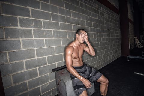 young male athlete sitting having a break in gym