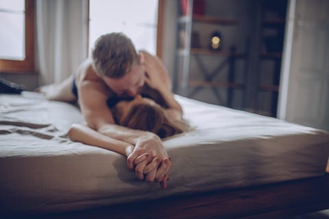 Young man and woman kissing in bed