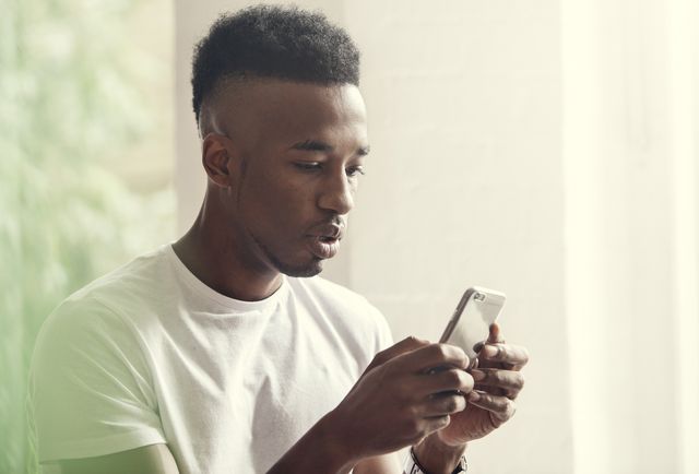 young man at a party texting