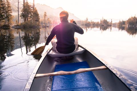Young man canoeing on Echo Lake, rear view, High Sierras, California, USA