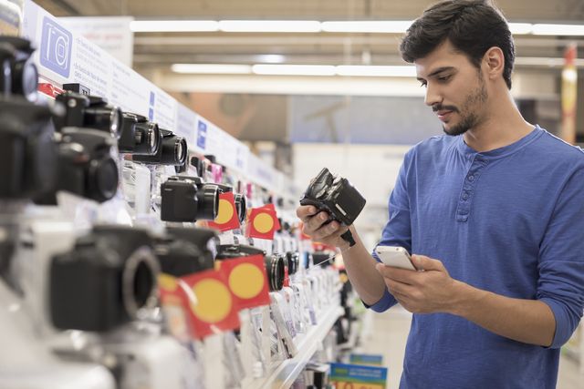 young man checking camera in store