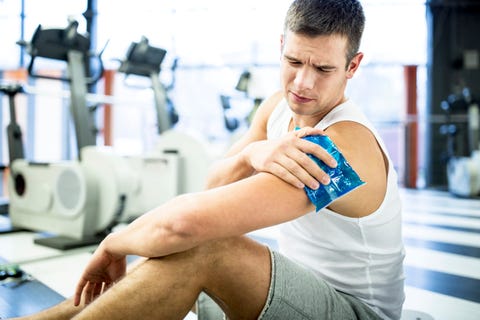 Young man holding ice pack on shoulder Young man holding ice pack on shoulder