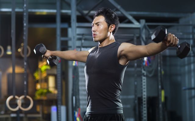 young man lifting weights at gym