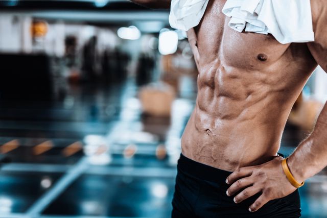young man tired after training showing his abdominal muscles