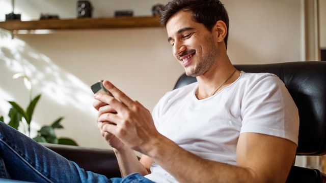 young man using smart phone at home