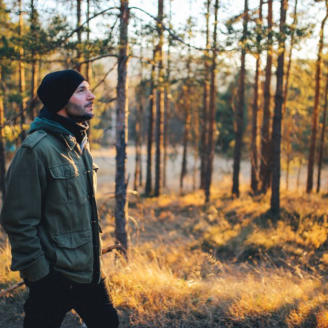 Young man walking in the beautiful forest outdoors
