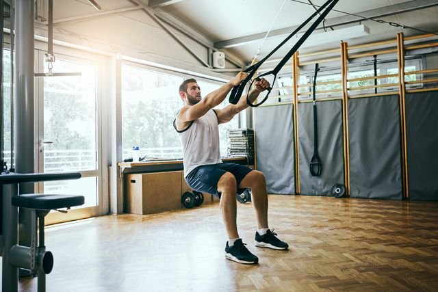 young man workout with trx suspension