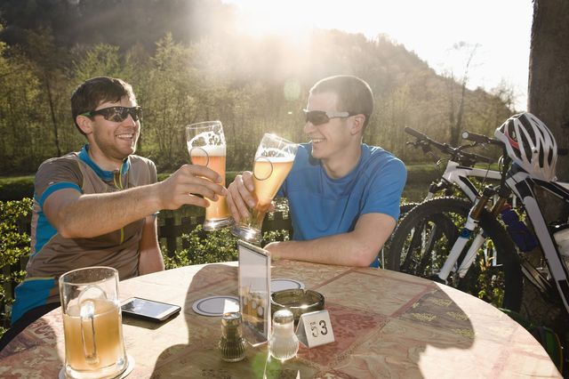 dos jóvenes ciclistas bebiendo cerveza