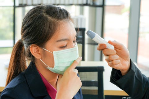 young pretty asian business woman employee was sick and wearing face protective mask and measured temperature for covid 19 virus infection