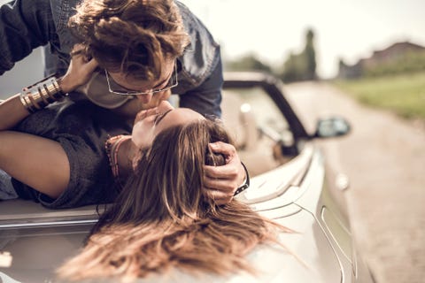 young romantic couple enjoying in their love on a convertible
