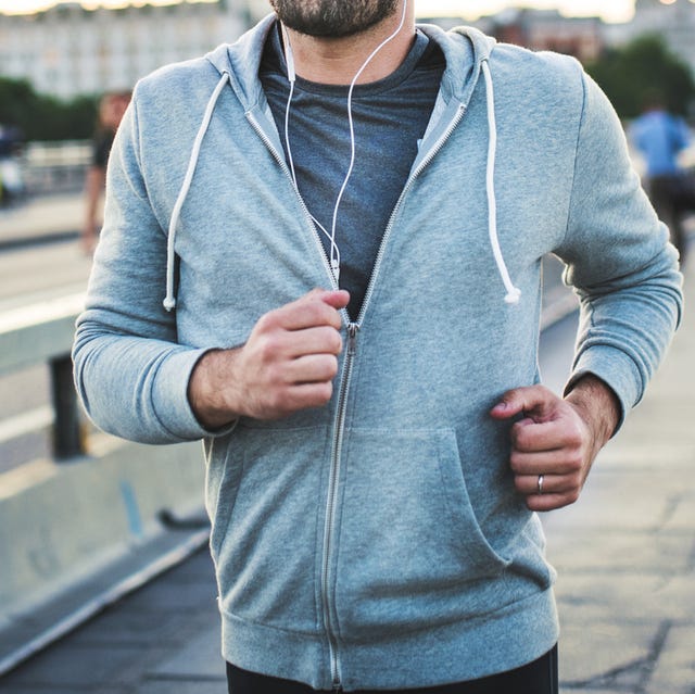 Young sporty man with earphones running on the bridge outside in a city. Young sporty man with earphones running on the bridge outside in a city.