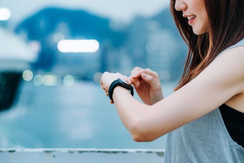 Young sporty woman checking her smart watch in city