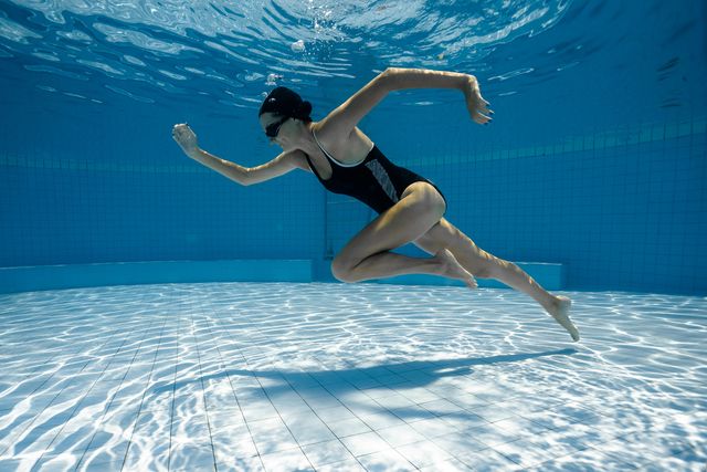 young sporty woman runs underwater