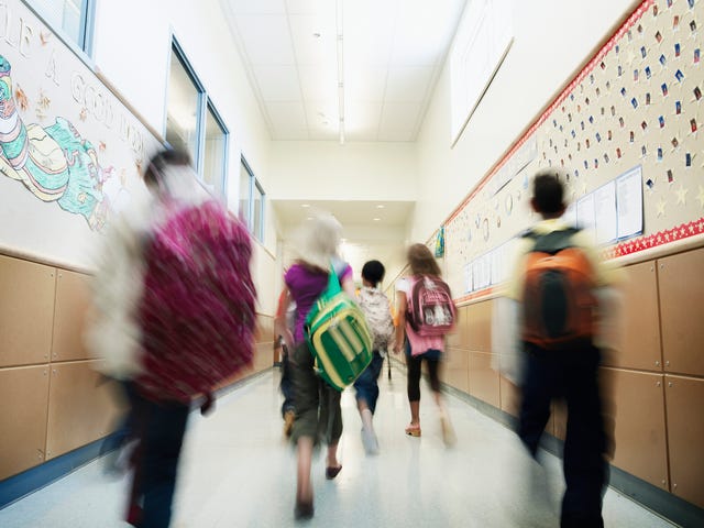 young students walking down hallway of school