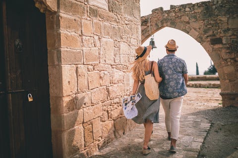 young tourists couple doing sightseeing at stonebuilt monument in europe