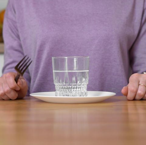 young woman at home drinks water and wants to eat intermittent fasting concept