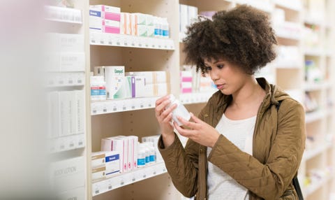 young woman choosing supplement in drugstore