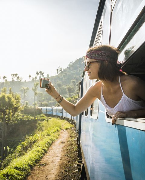 Young woman classic Ella train ride, taking smart phone pic