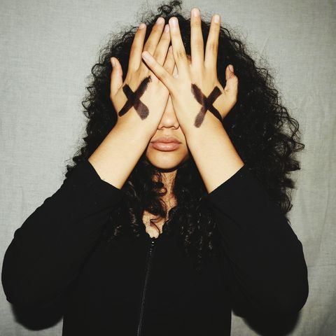 young woman covering eyes with hands